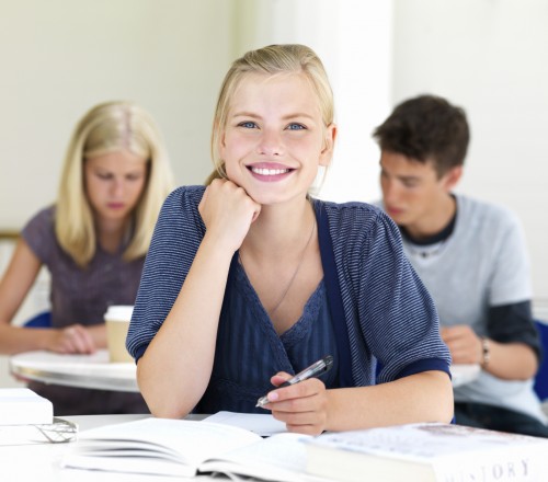 Portrait of happy young girls writing notes